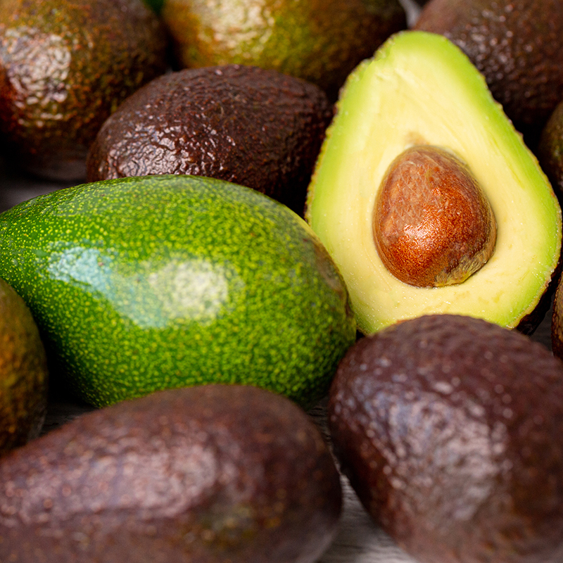 Cutted avocado fruit next to other one